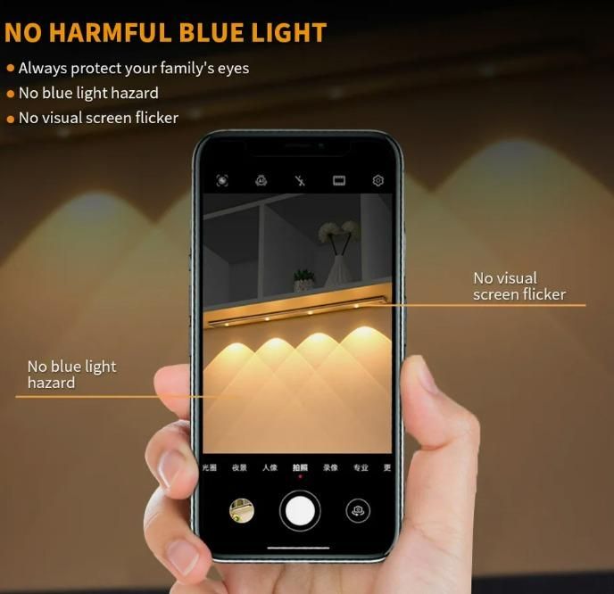 Hand holding a smartphone with a screen displaying a room's interior, emphasizing no harmful blue light features.