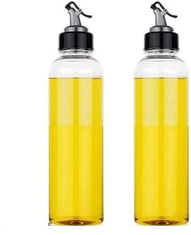 Two glass bottles filled with yellow liquid, likely oil or vinegar, on a white background.